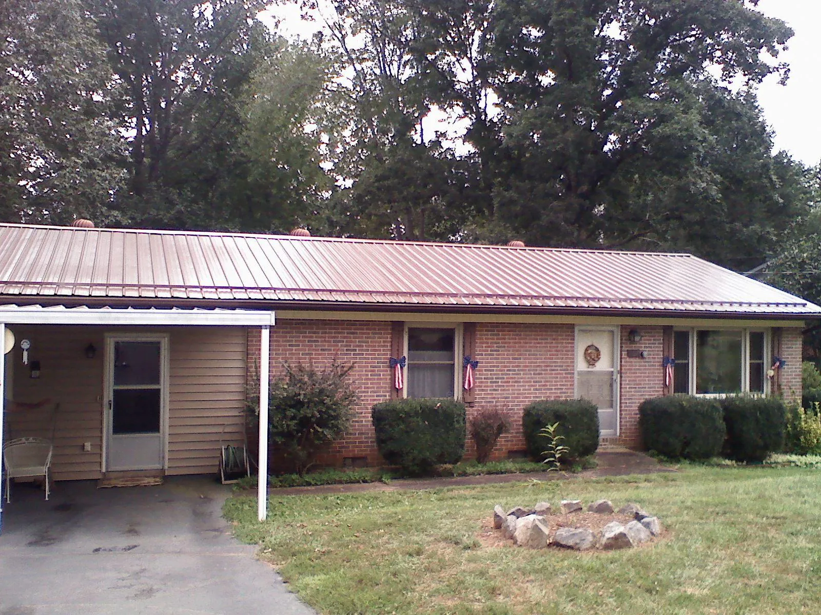 Bronze metal roof and carport on a brick ranch home — Roof Repair work by our crew in Clarksville